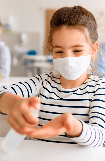 niña desinfectando sus manos con gel antibacterial